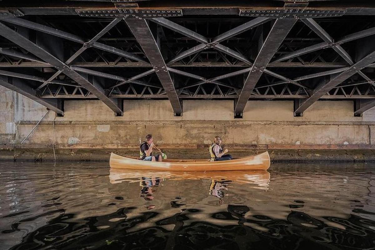 due uomini in canoa nell'acqua sotto un ponte
