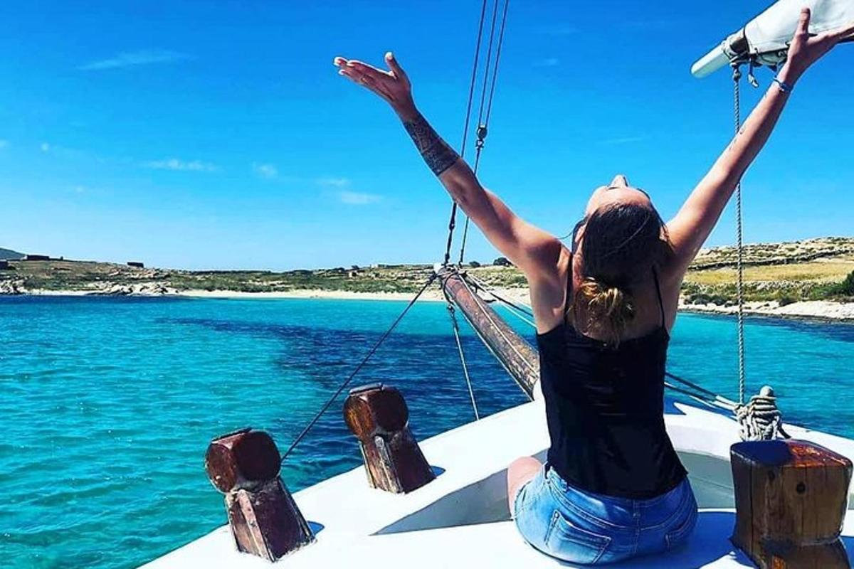 a woman sitting on a boat with her arms in the air