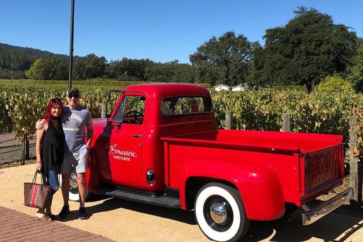 a man and a woman standing next to a red truck
