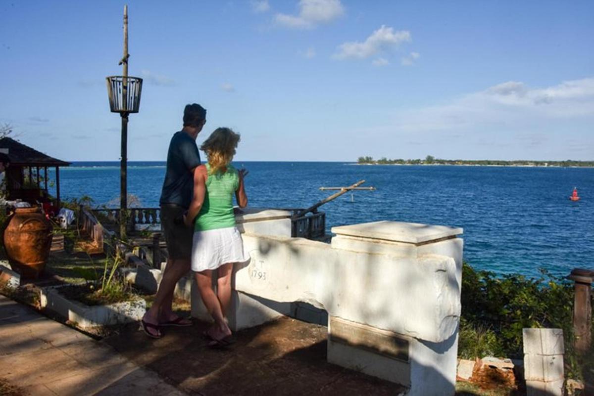 a man and a woman standing next to the water