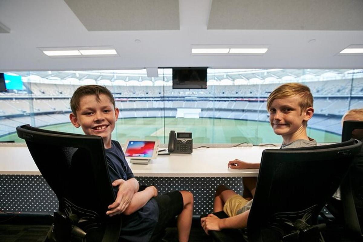 two young boys sitting at a table in an arena