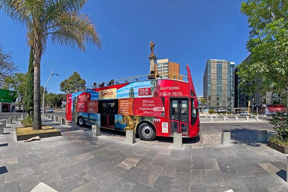 a red double decker bus parked in a parking lot