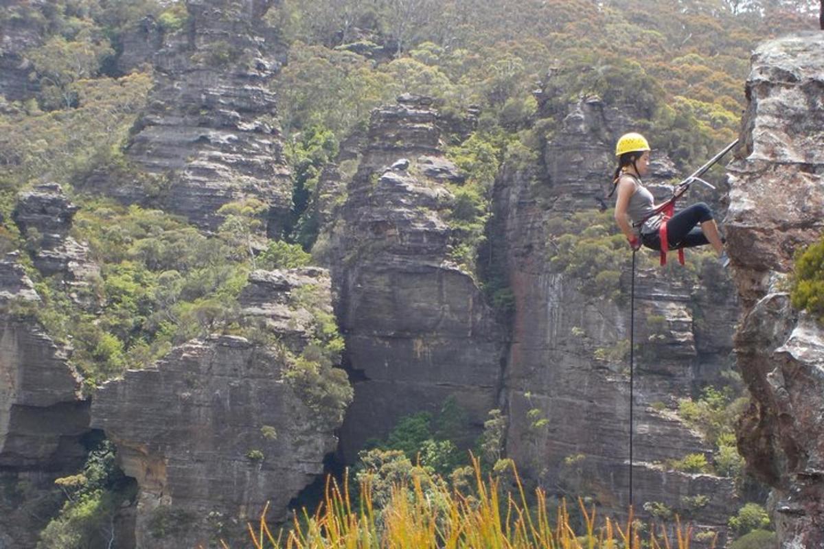 a woman is rappelling off of a cliff