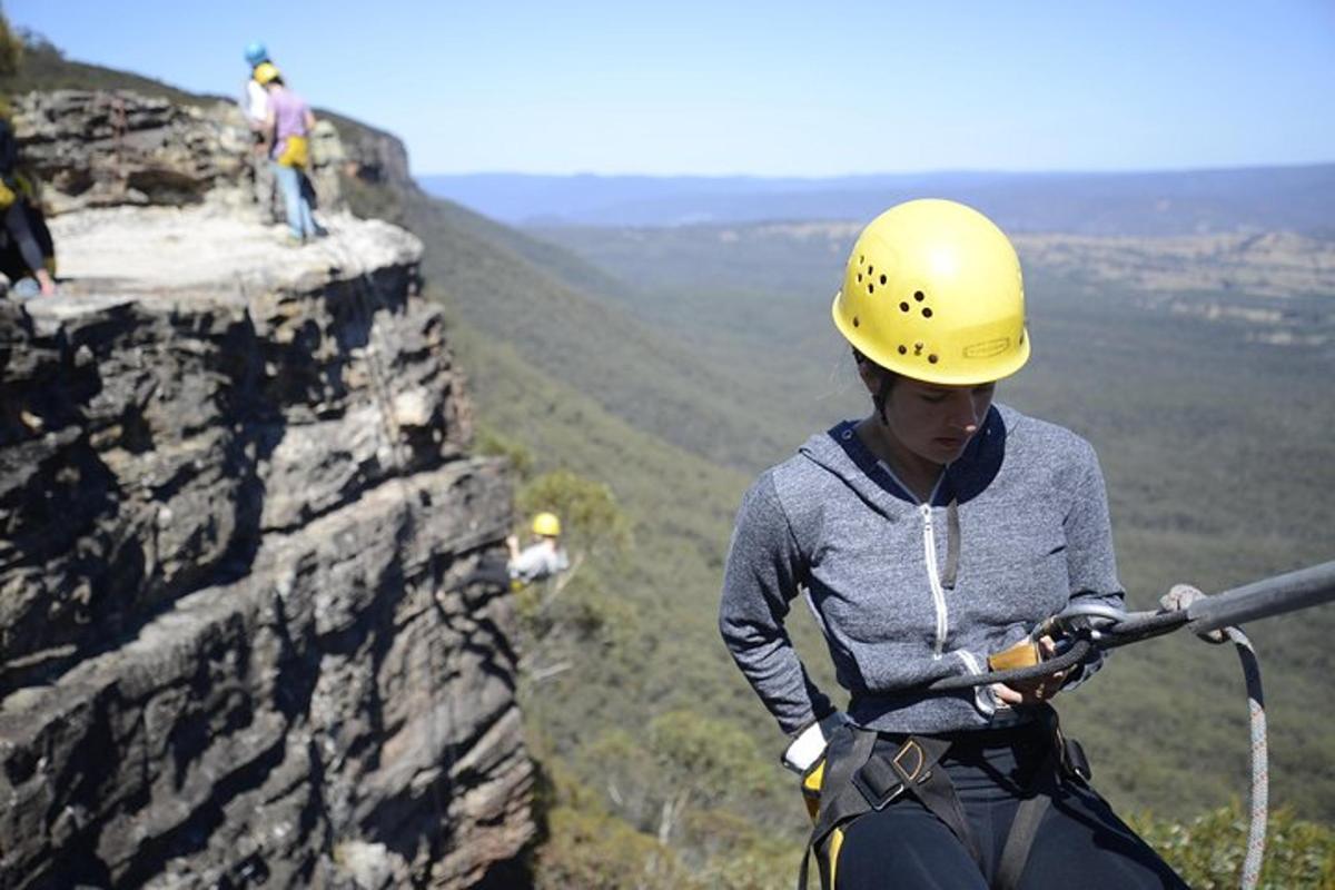 a woman in a hard hat standing on a cliff