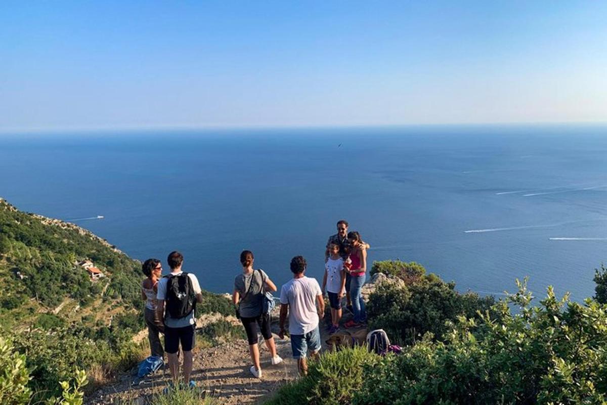 grupa ljudi koja se penje uzbrdo s pogledom na ocean