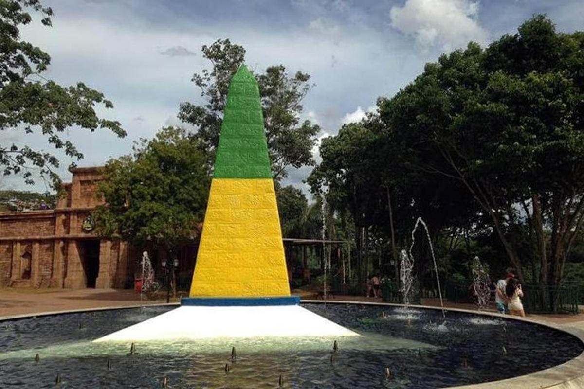 a fountain with a colored pyramid in a park