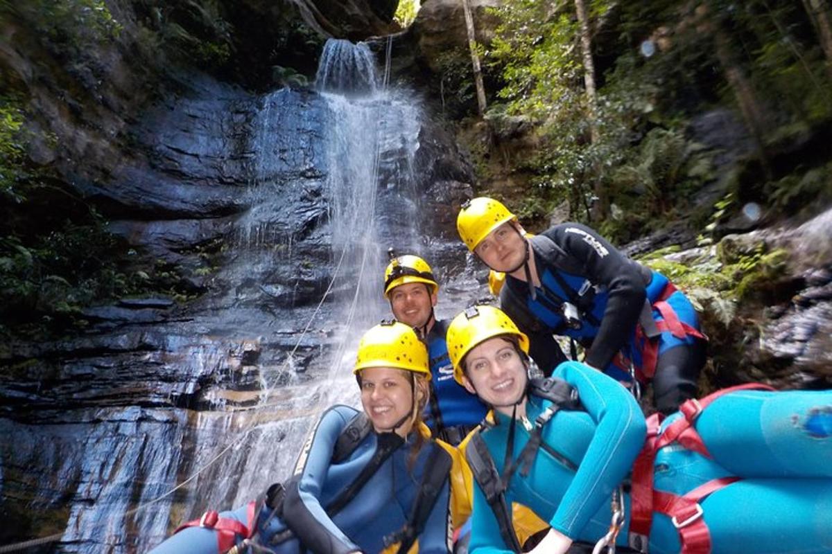 a group of people on a raft in front of a waterfall