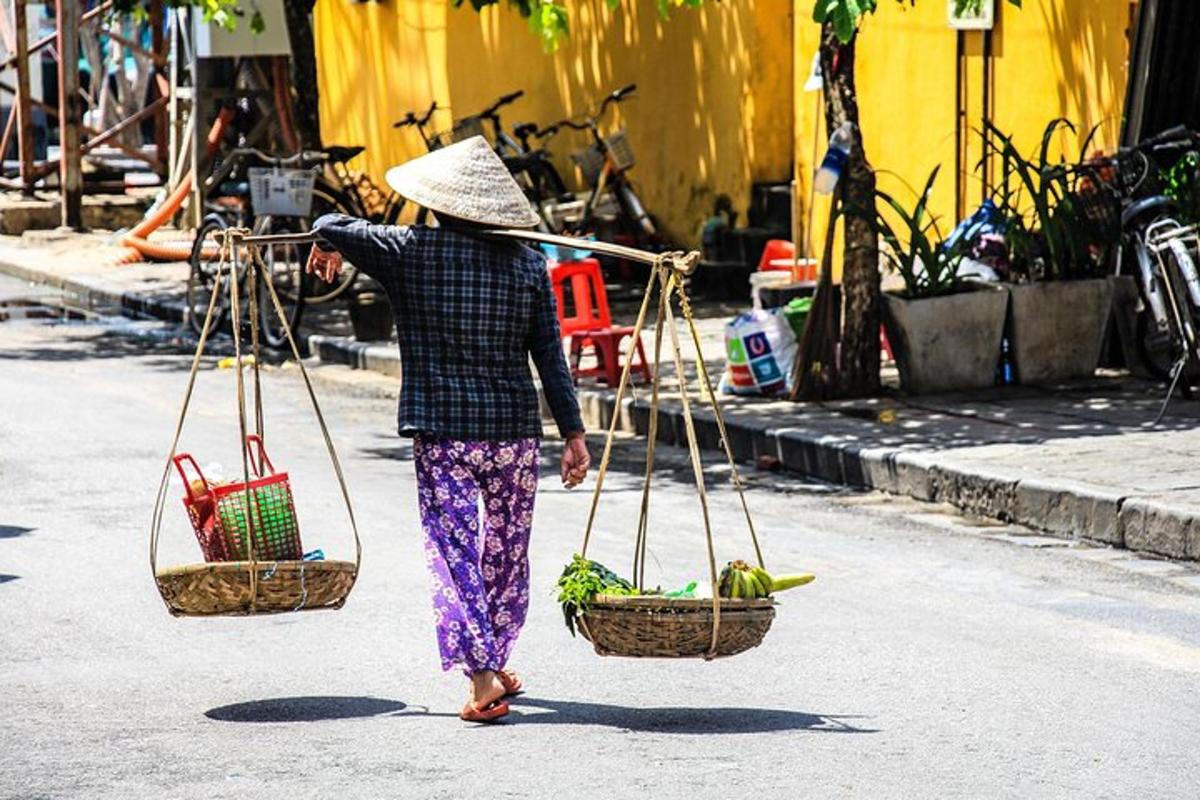 uma mulher caminhando pela rua carregando cestas