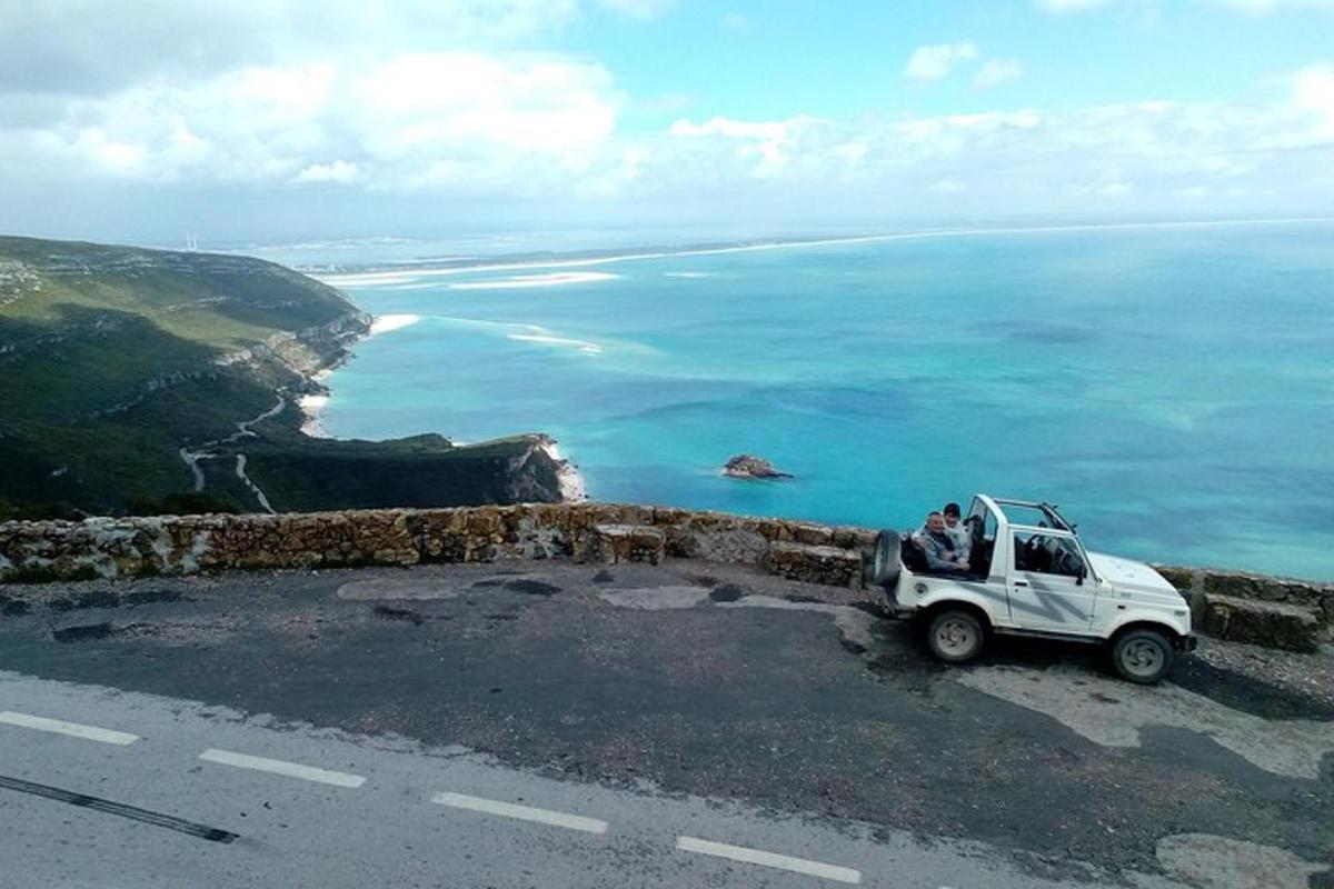 a white truck parked on the side of a road near the ocean