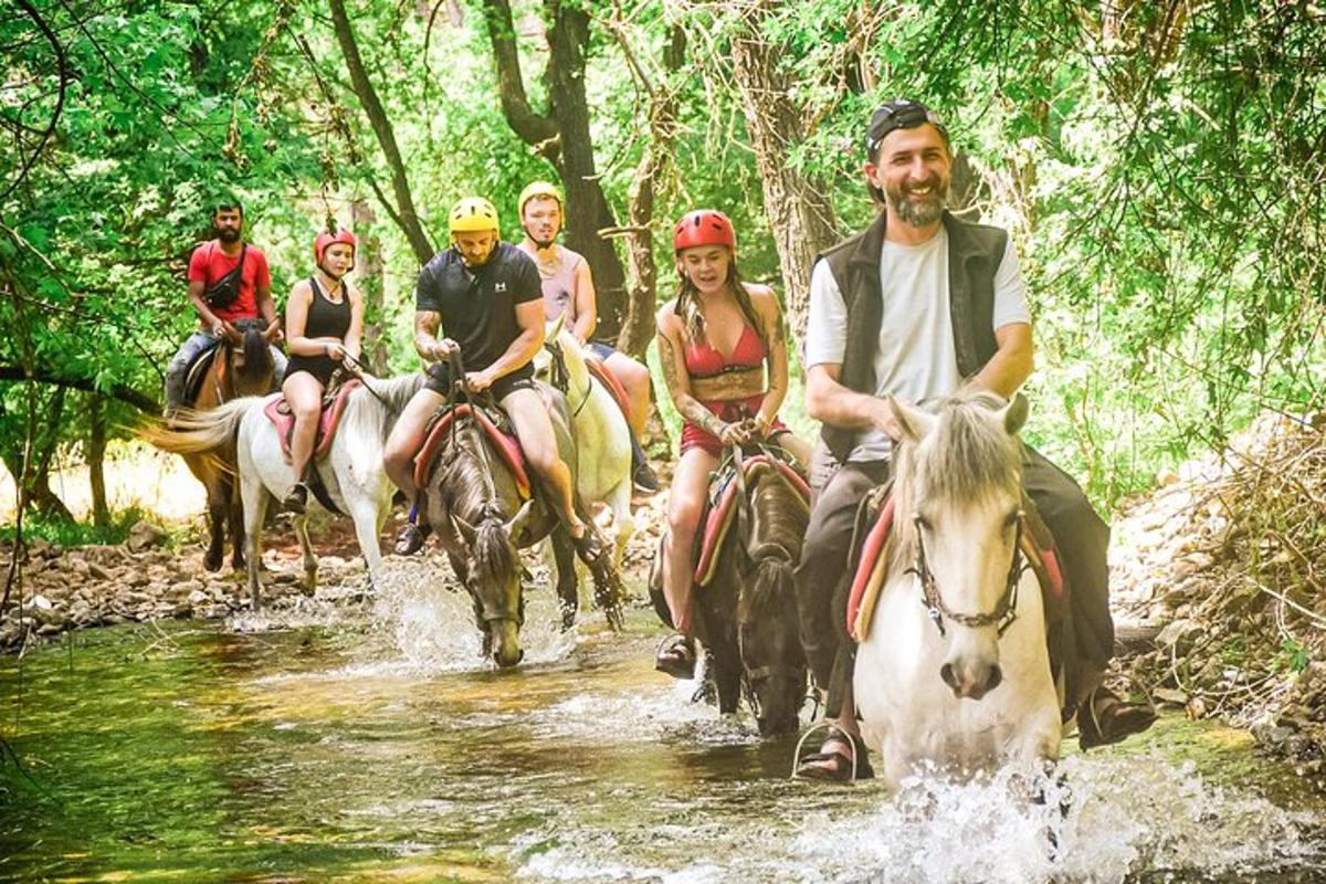 un grup de persones muntant a cavall per un riu