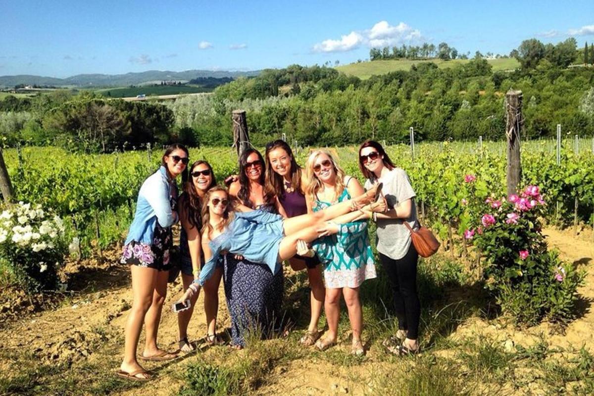 un grup de persones posant per a una foto en una vinya