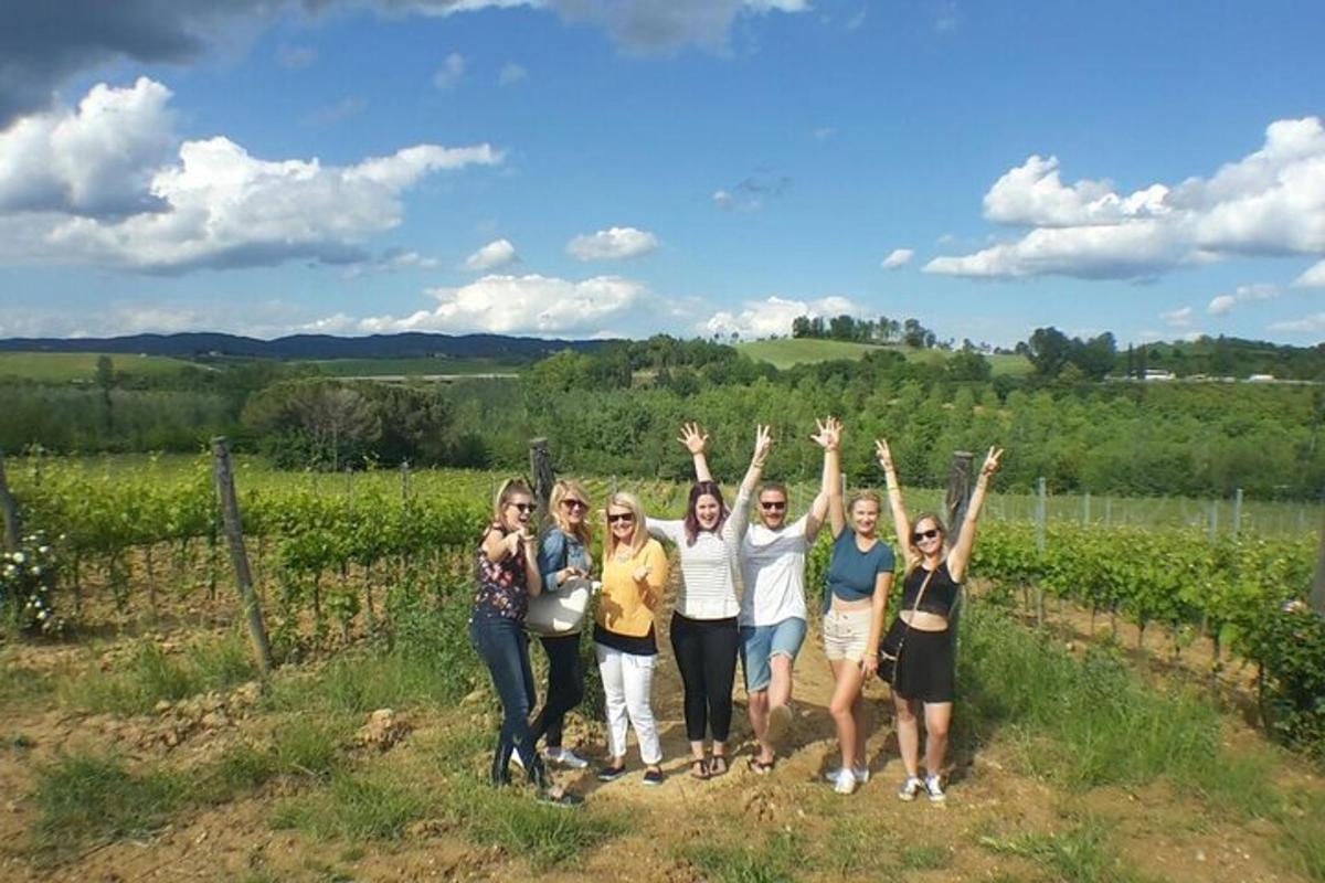 a group of people standing in front of a vineyard