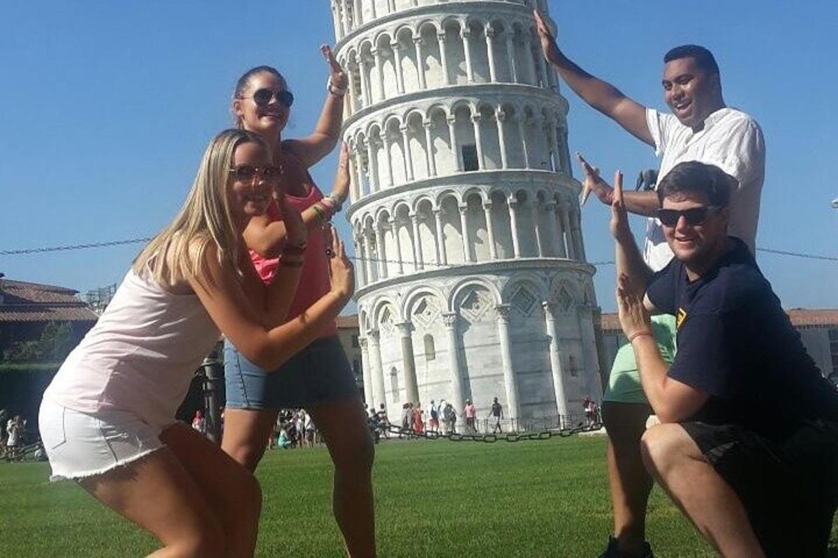 a group of people posing in front of the leaning tower