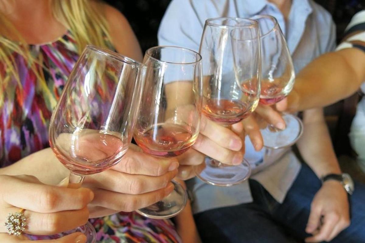 un grup de oameni care țin în mână pahare de vin