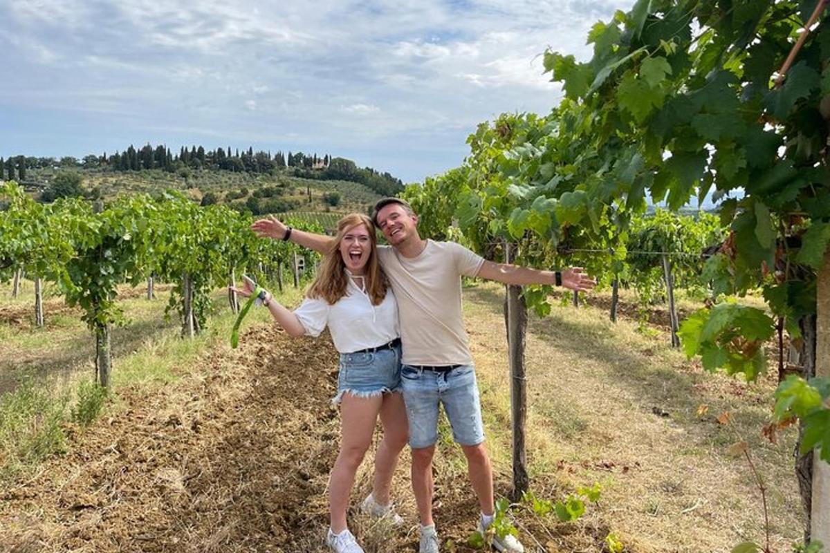 moški in ženska stojita v vinogradu