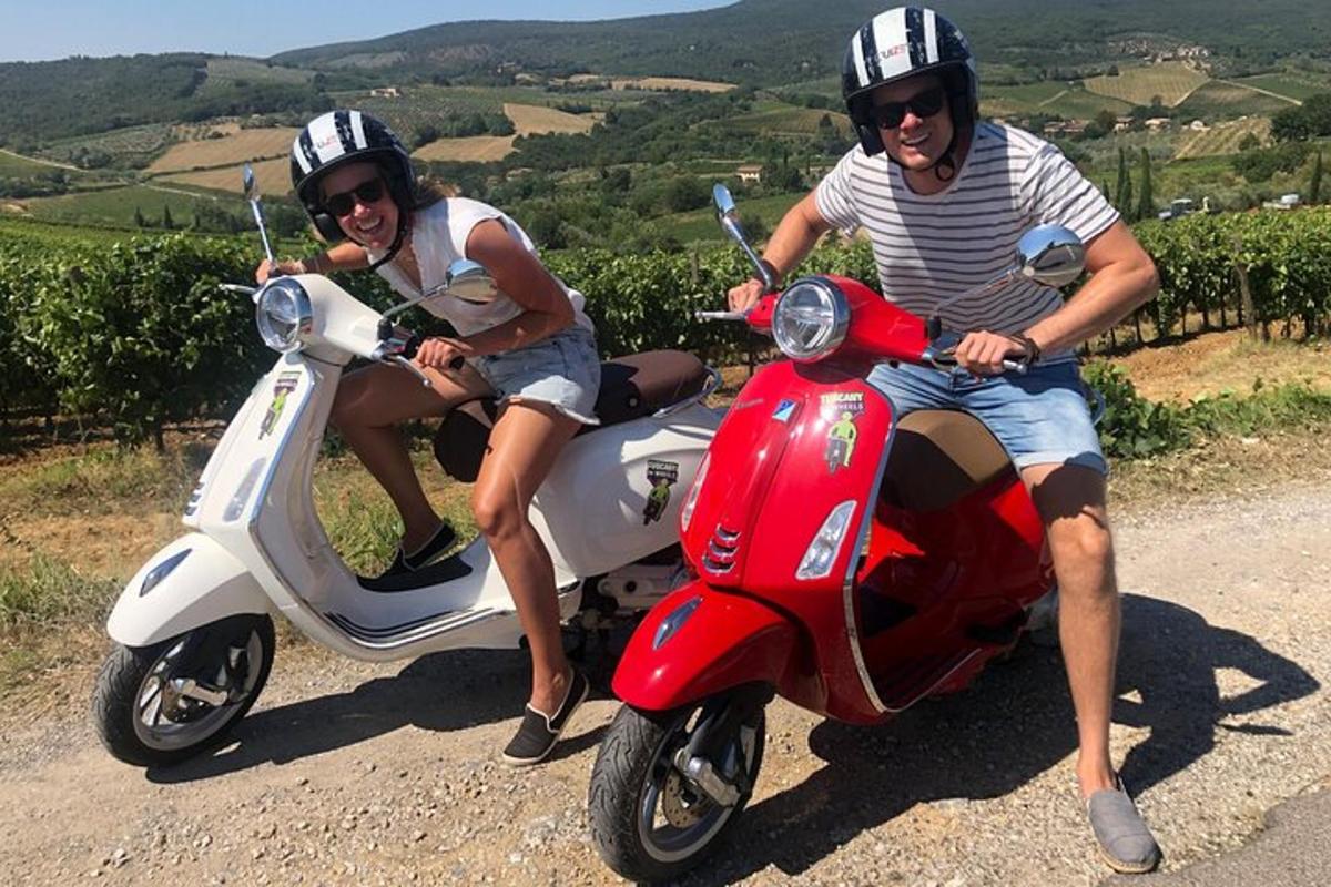dva lidé sedící na skútru na silnici