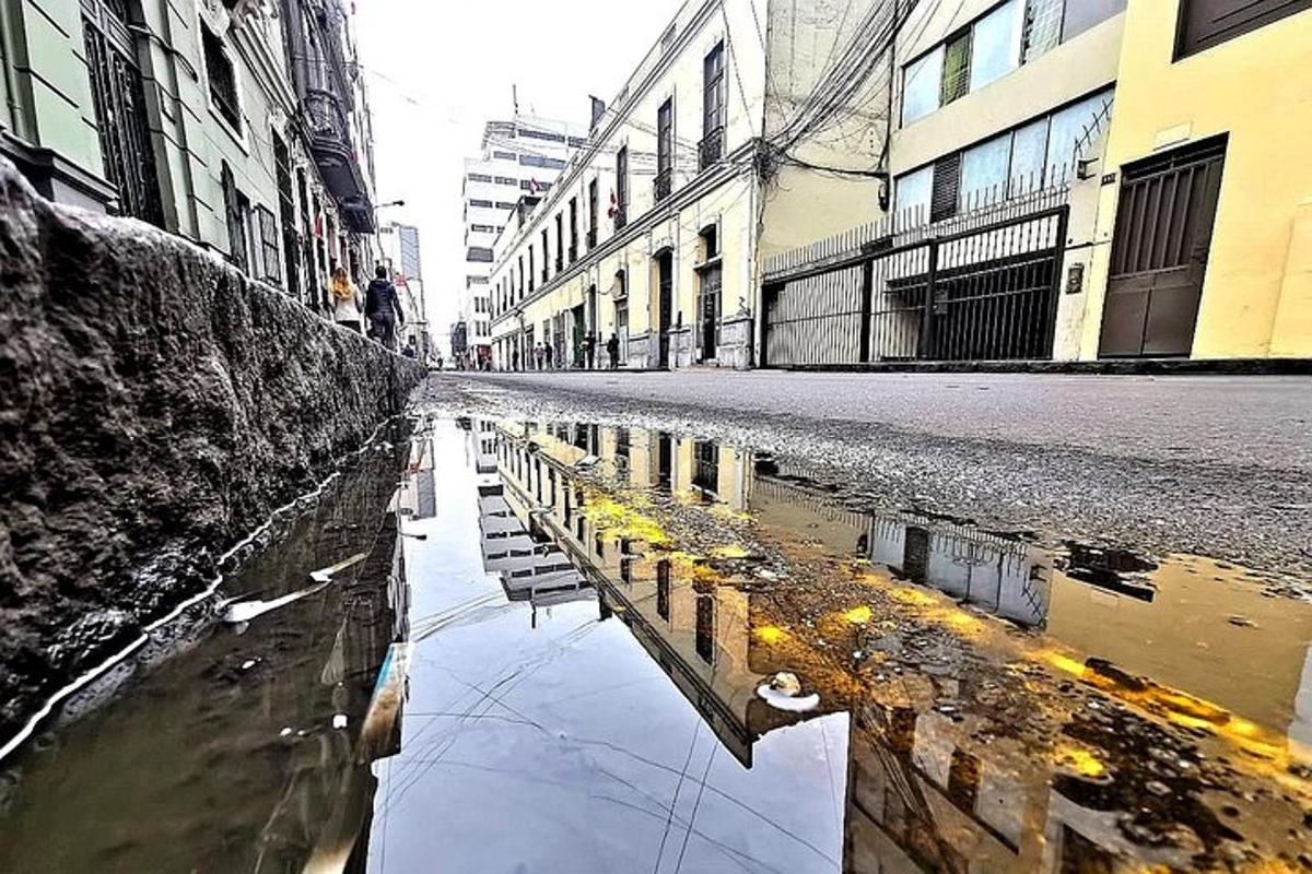 uma poça d'água em uma rua da cidade com prédios
