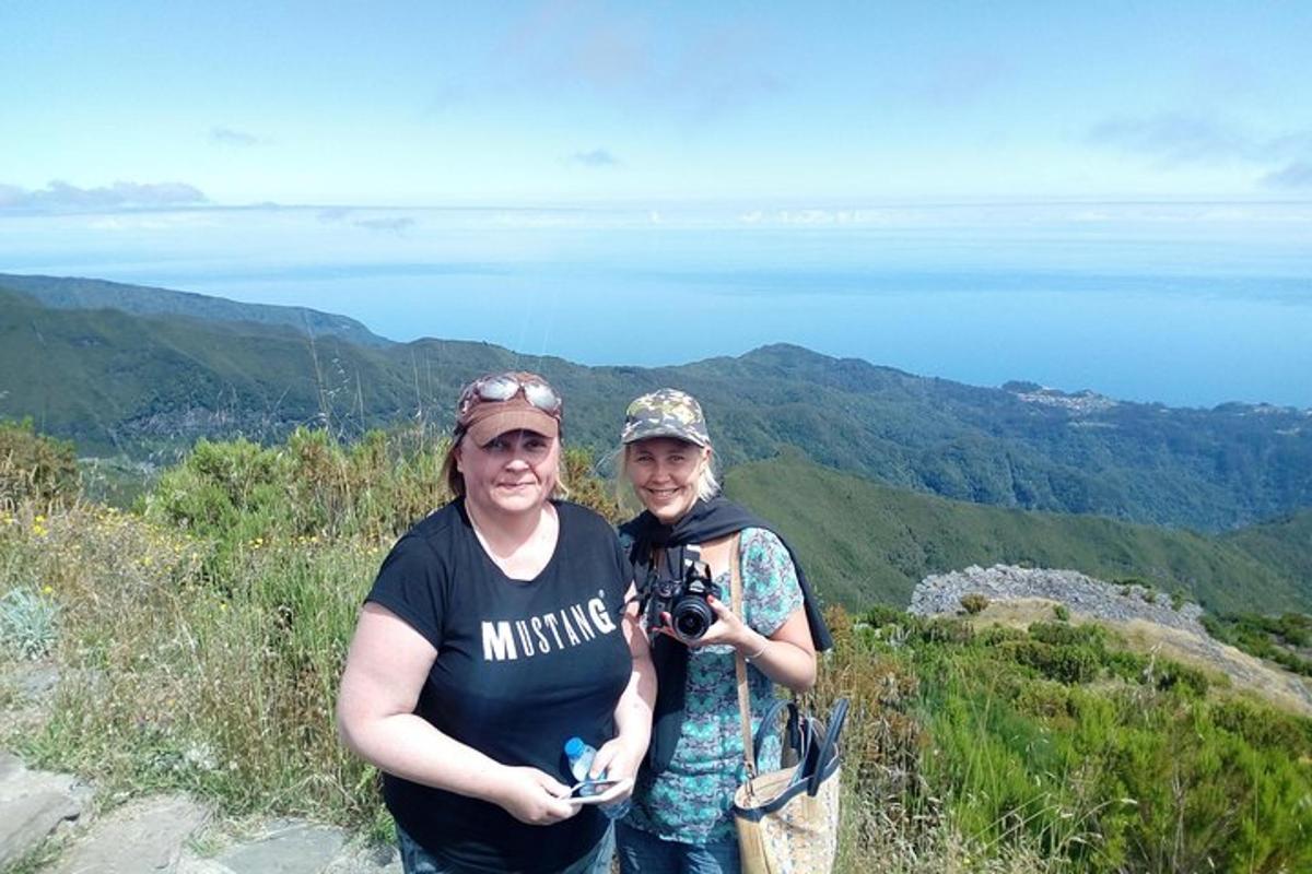 duas pessoas em pé no topo de uma montanha com uma câmera
