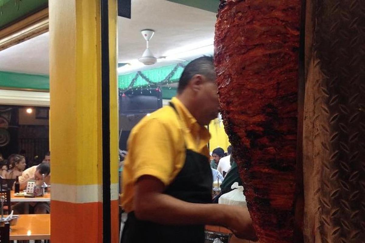 a man standing behind a counter in a restaurant