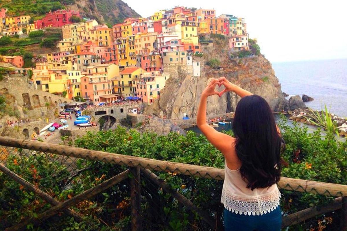una donna in piedi su una recinzione che guarda una città