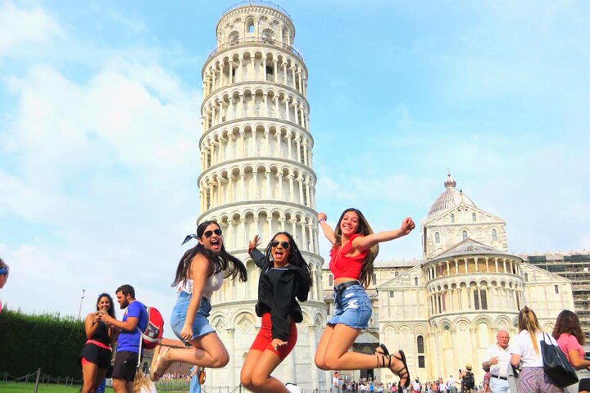 persone che saltano davanti alla torre pendente di Pisa