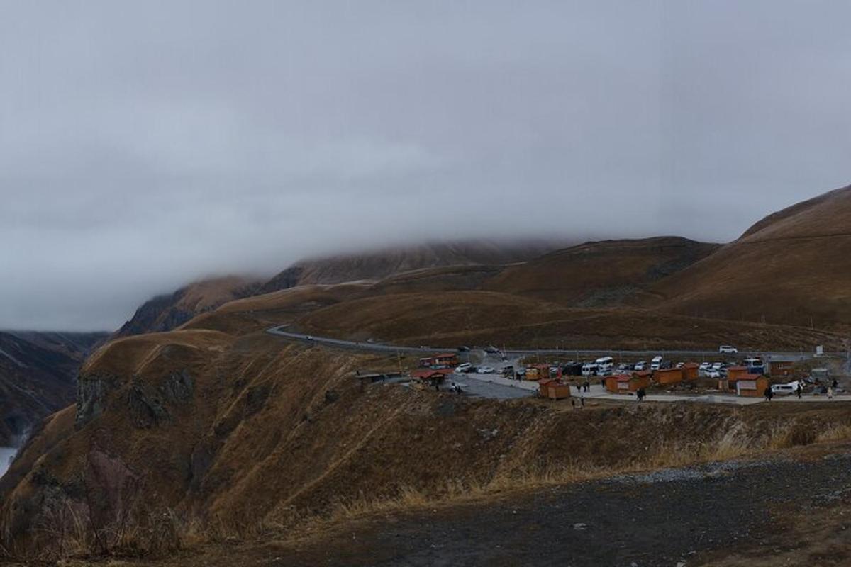 un gruppo di edifici su una collina con una montagna nebbiosa