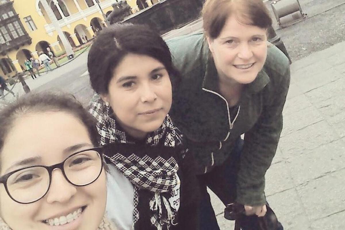 dua wanita dan seorang pria berpose untuk foto