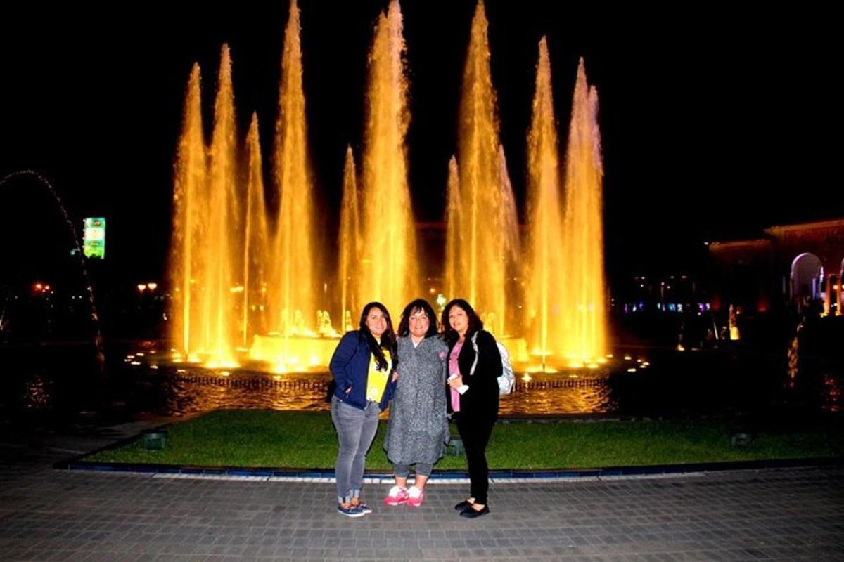 tre donne in piedi davanti a una fontana di notte