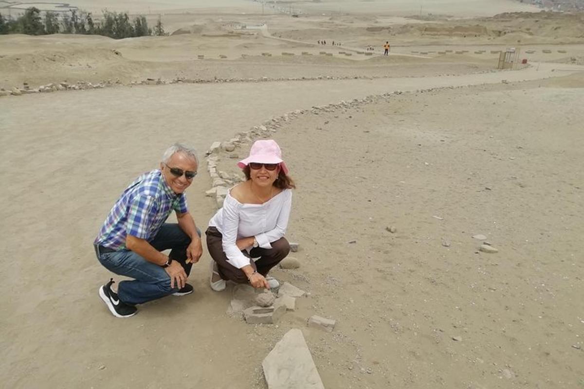 a man and woman building a rock structure on the beach