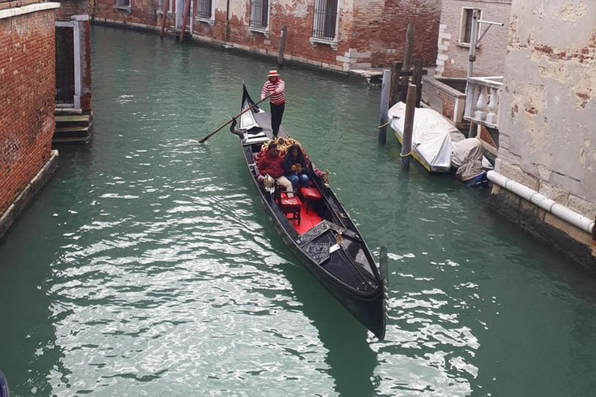 seorang pria berdiri di atas perahu di kanal