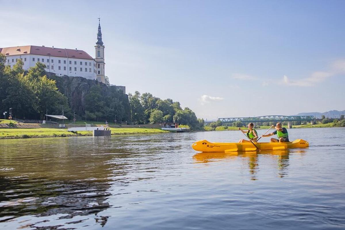 dva lidé ve žlutém voru na řece
