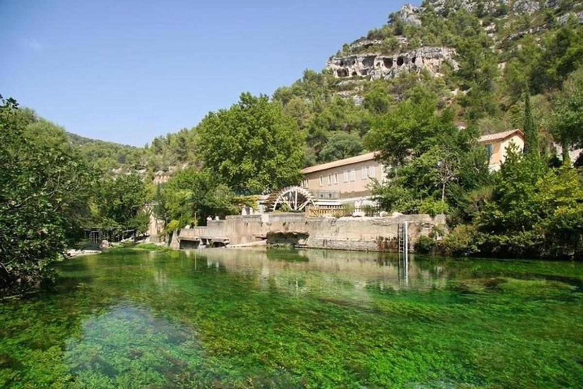 un riu amb un pont i un edifici en un turó