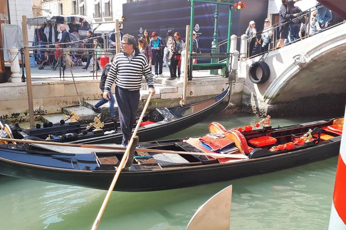một người đàn ông đứng trên thuyền gondola dưới nước