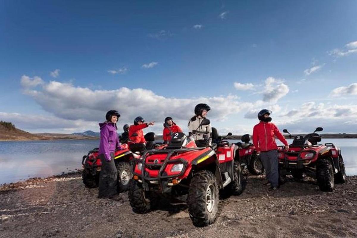 egy csoport ember áll ATV-k körül egy tavon