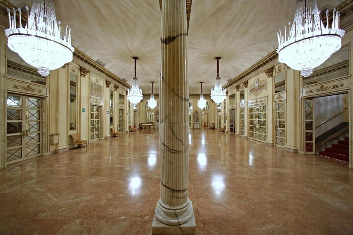 Una gran sala con candelabros y una columna en un edificio.