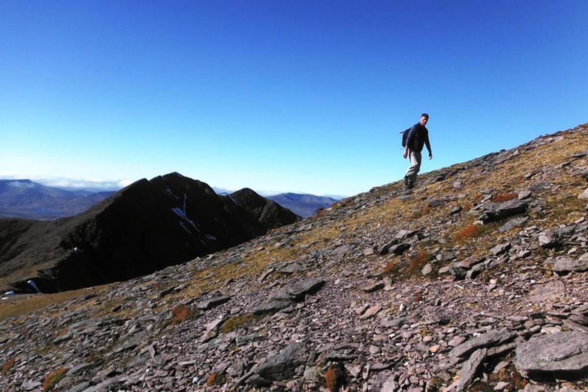 un hombre parado en la ladera de una montaña