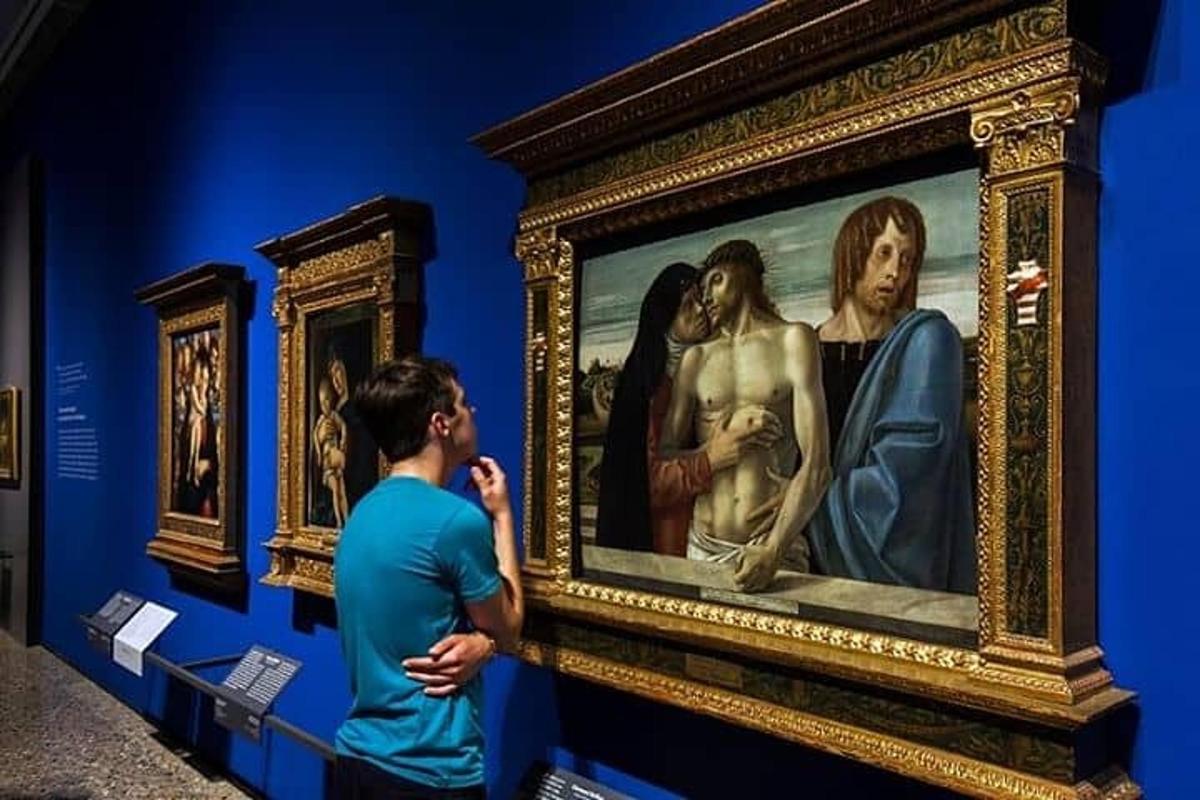 a man taking a picture of a painting in a museum