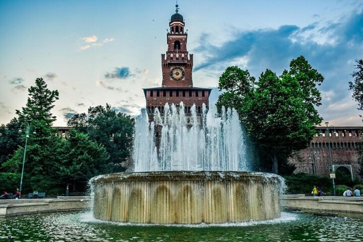 Una fuente de agua con una torre de reloj al fondo
