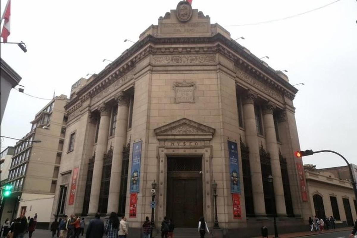 um grande edifício em uma rua da cidade com pessoas na frente