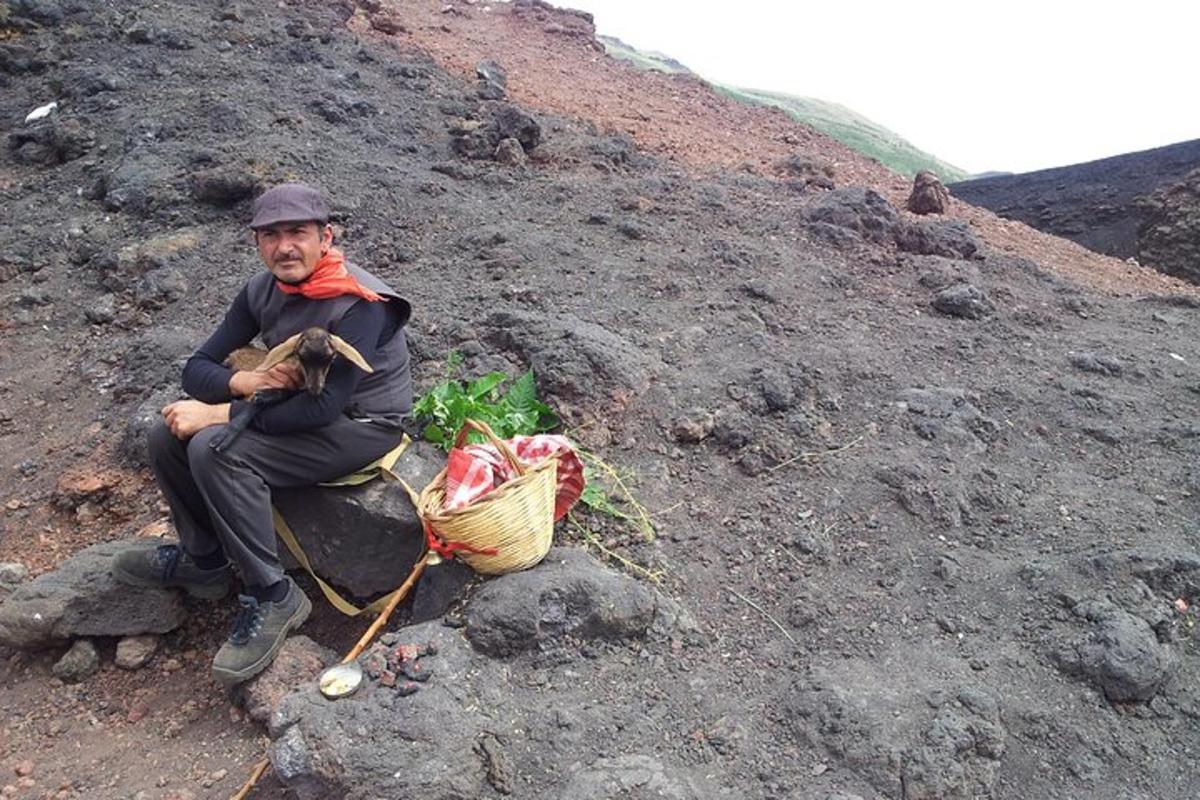 a man sitting on a rock with a basket of vegetables