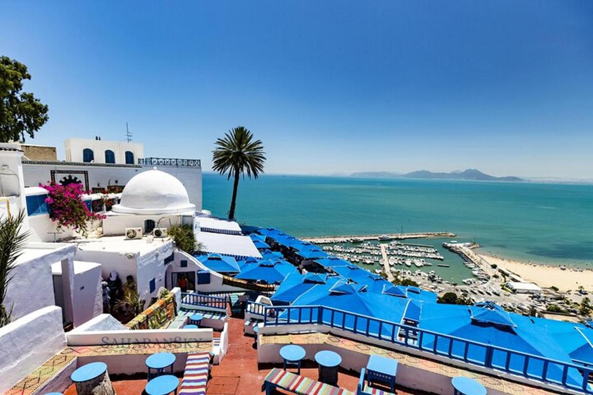a view of the beach from a resort with blue umbrellas
