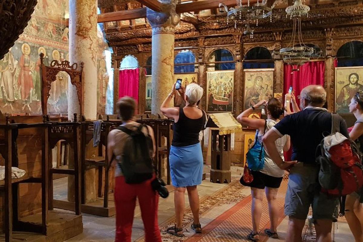cilvēku grupa, kas baznīcā fotografē gleznu