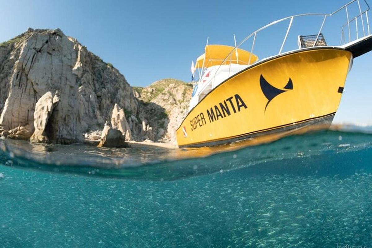μια κίτρινη βάρκα στο νερό δίπλα σε έναν βράχο