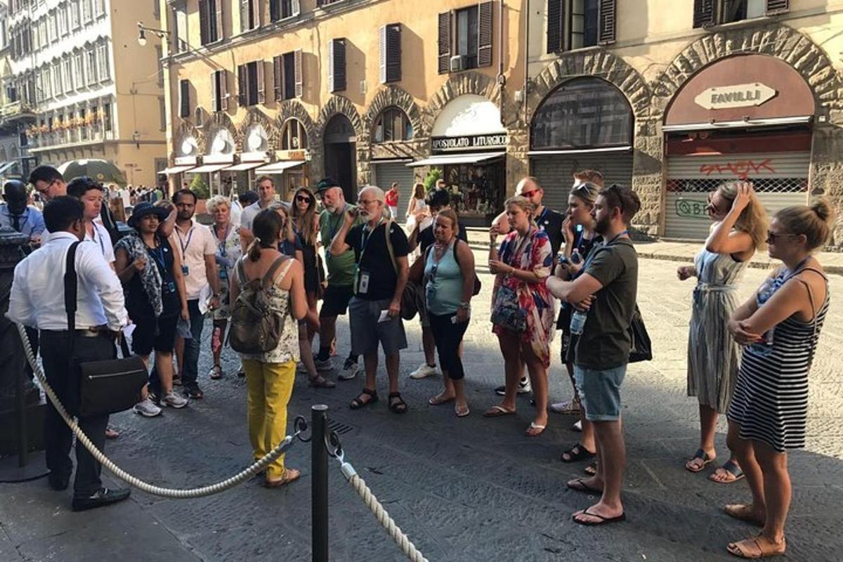 una folla di persone in piedi su una strada di una città
