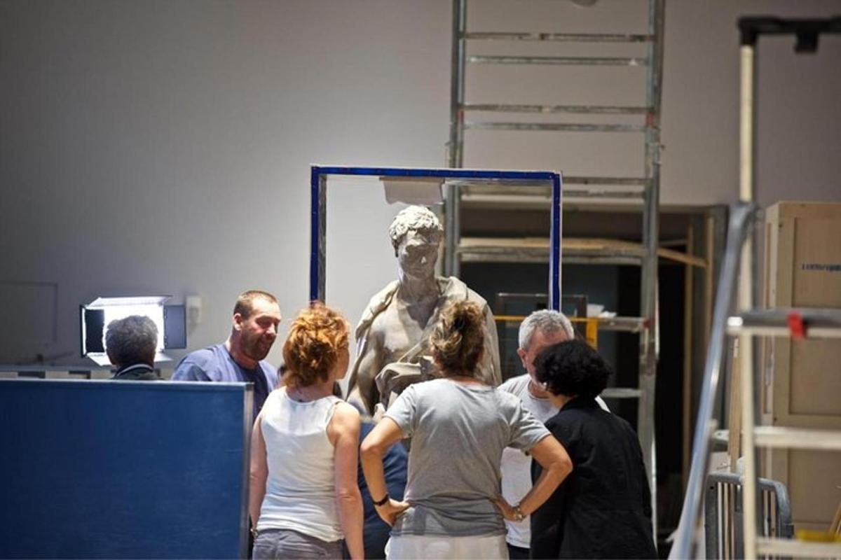 un gruppo di persone in piedi davanti a una statua