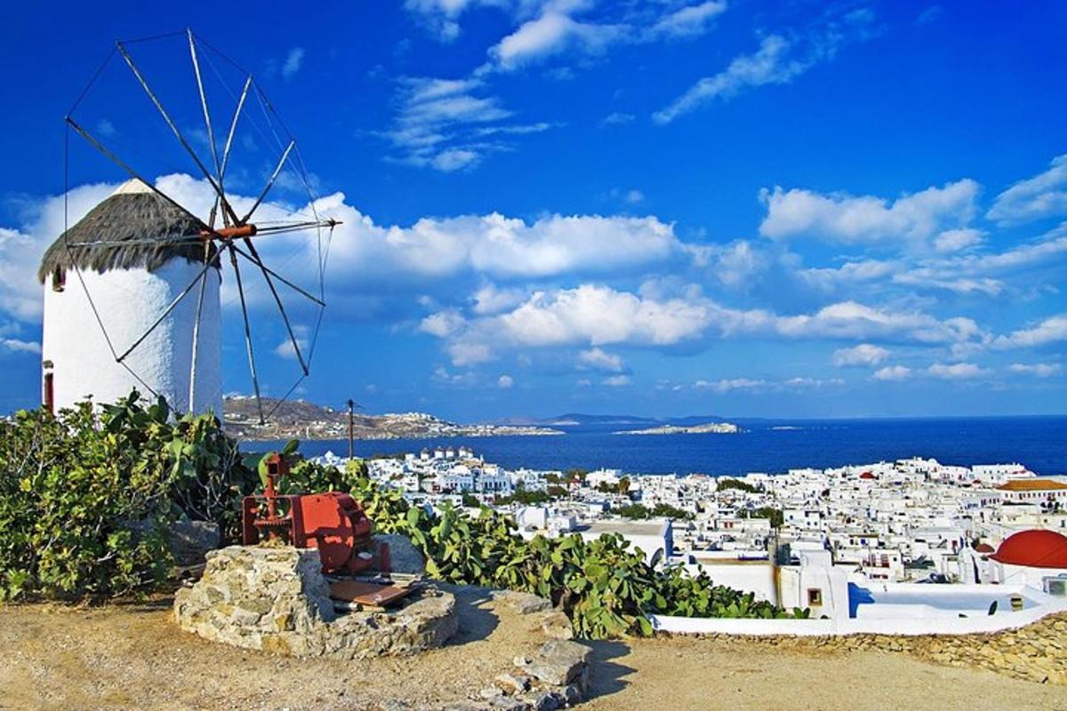 un mulino a vento su una collina con una città sullo sfondo