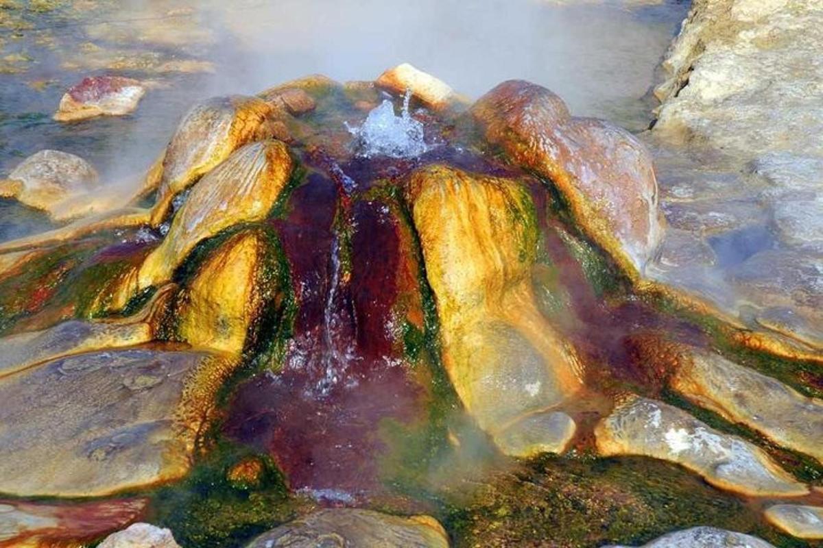 Una pintura de una formación rocosa en el agua.