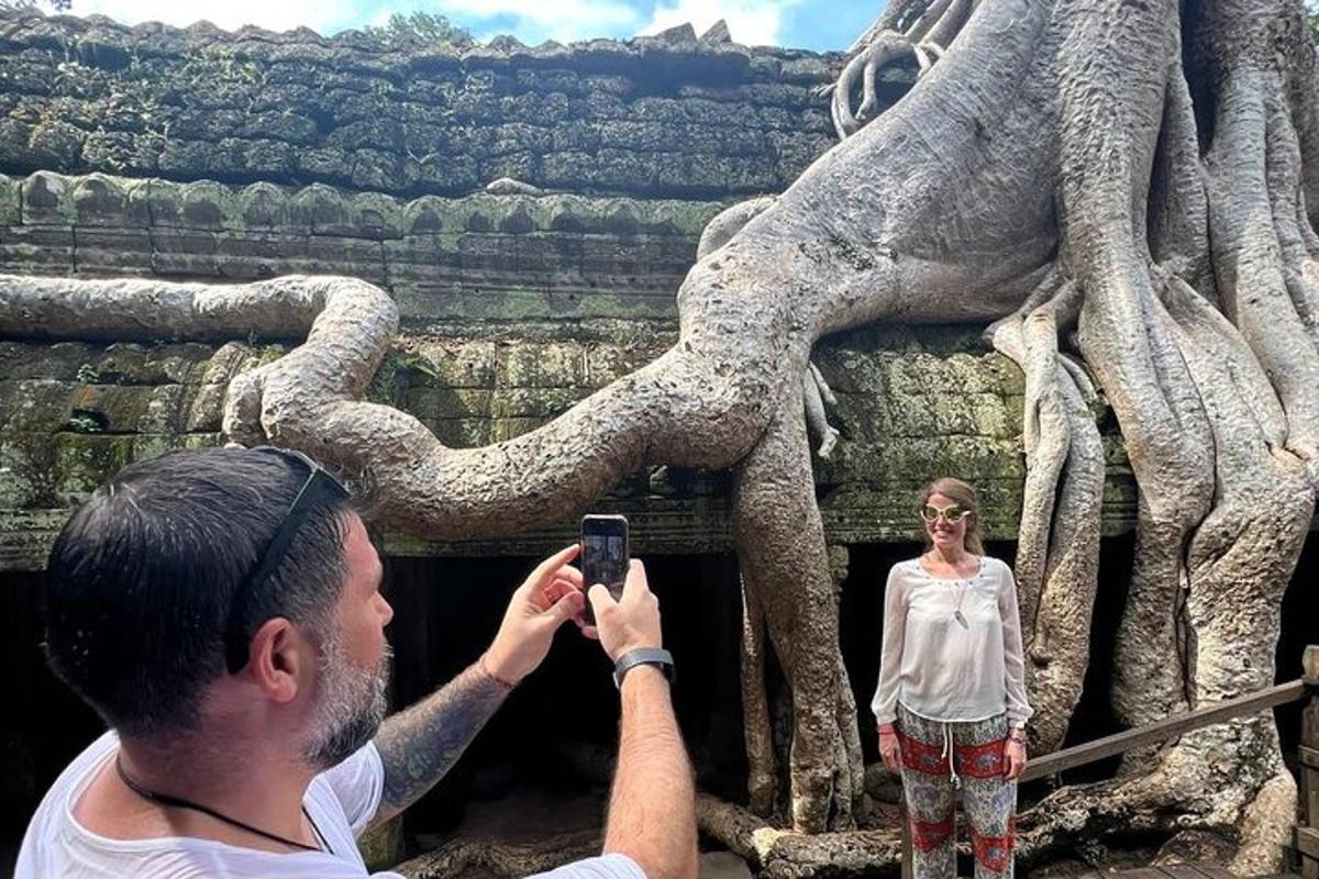 чоловік фотографує жінку перед статуєю