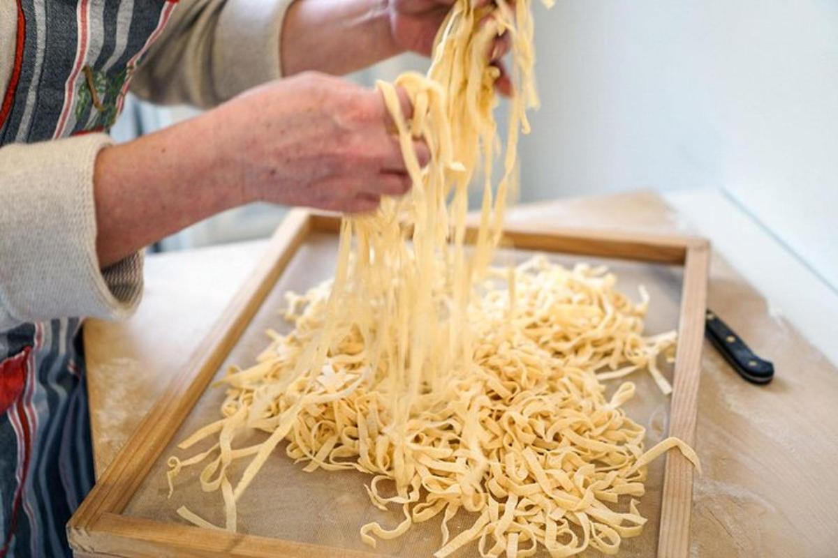 una persona sosteniendo una pila de fideos en una tabla de cortar