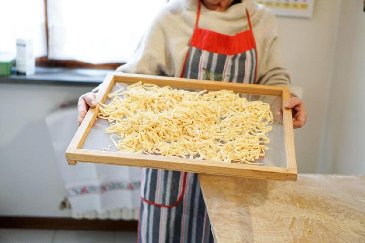 Una mujer sostiene una bandeja de pasta.